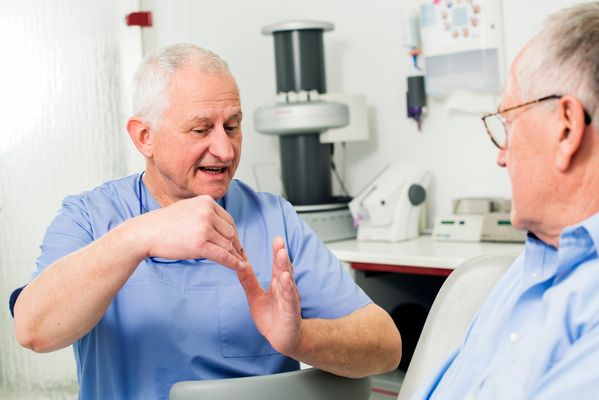 Funktionsdiagnostik Zahnarzt im Gespräch mit einem Patienten